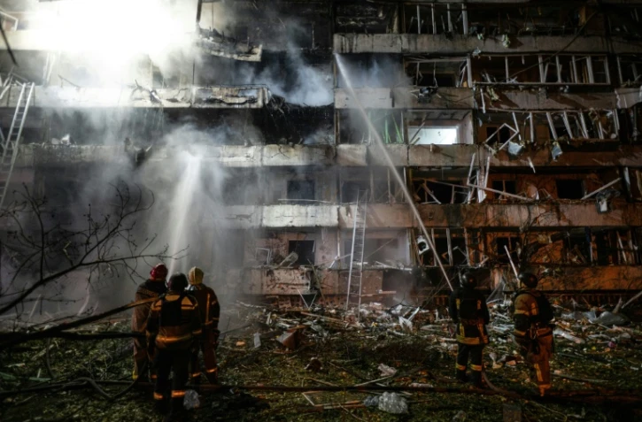 Des pompiers sur le site d'une frappe de missile russe contre un immeuble résidentiel à Kiev, le 14 octobre 2026 en Ukraine