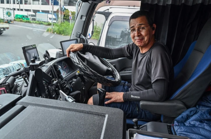 Le chauffeur routier Fujio Uemura au volant de son camion dans une zone industrielle de Kawasaki, le 4 septembre 2024 au Japon