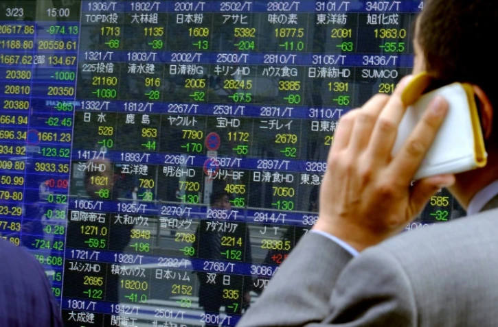 Un écran montrant l'évolution des indices de la Bourse de Tokyo le 23 mars 2018. Le Nikkei est tombé au plas bas sur fond de craintes de guerre commerciale