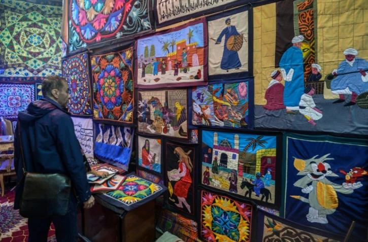 Un homme contemple des khayamiya égyptiens (patchworks) dans une boutique du Caire, le 18 décembre 2018