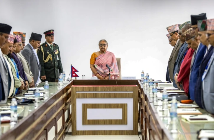 La nouvelle Première ministre du Népal Sushila Karki (C) lors d'une minute de silence observée en mémoire des victimes des émeutes meurtrières à Katmandou qui ont fait au moins 72 morts, le 14 septembre 2025 à Katmandou