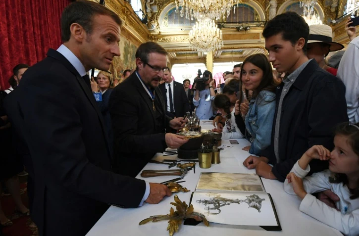 Le président Emmanuel Macron (G) rencontre des jeunes visiteurs à l'Elysée, lors des journées du patrimoine, le 15 septembre 2018