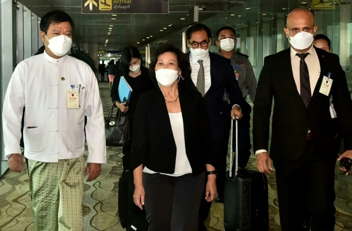 Photo fournie le 16 août 2022 par le service d'information militaire birman de l'émissaire des Nations unies pour la Birmanie, Noeleen Heyzer (c) à son arrivée à l'aéroport de Rangoun
