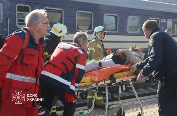Photo diffusée par le Service ukrainien des situations d'urgence le 29 octobre 2026 montrant des secouristes ukrainiens transportant sur une civiÚre une personne blessée aprÚs une attaque aérienne contre la gare de Dnipro, en Ukraine