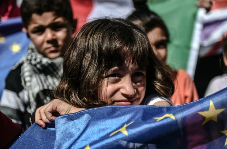 Une jeune migrante brandit un drapeau européen lors d'une manifestation de réfugiés à Istanbul, en Turquie, le 19 septembre 2015