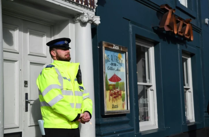 Un policier britannique monte la garde le 6 mars 2018 devant un restaurant de la chaîne Zizzi à Salisbury, fermé en lien avec un mystérieux empoisonnement présumé d'un ex-espion russe