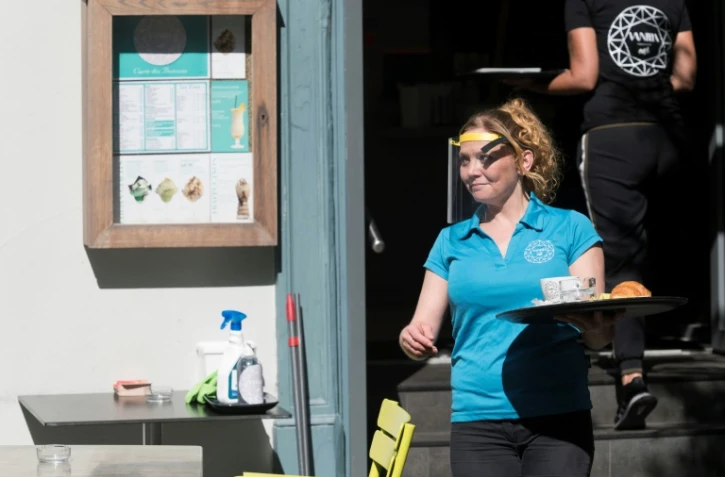 Une serveuse avec une visière de protection, à la terrasse d'un café à Mulhouse, le 2 juin 2020