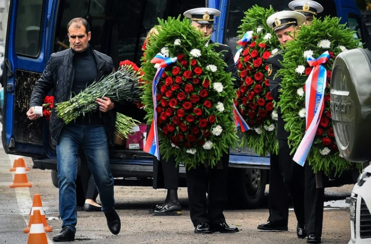 Des militaires de la Marine russe transportent des couronnes mortuaires avant les funérailles des 14 officiers tués dans l'incendie d'un petit sous-marin nucléaire, le 6 juillet 2019 à Pétersbourg