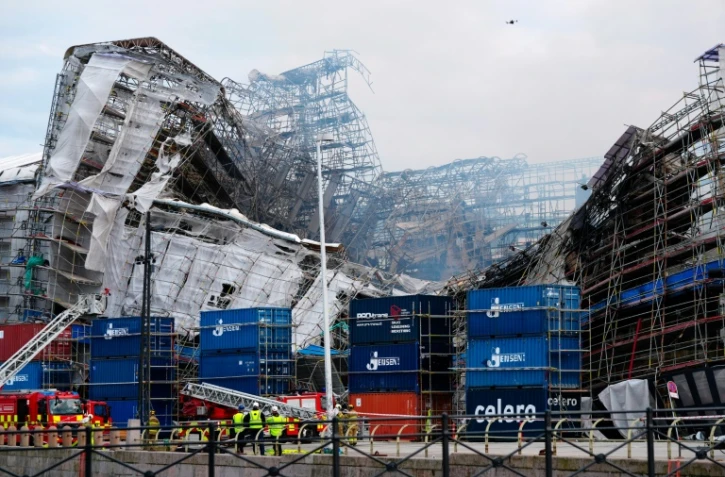 Des pompiers devant la façade principale de l'ancienne Bourse de Copenhague qui s'est effondrée, deux jours après un incendie qui l'a ravagée, le 18 avril 2024 au Danemark