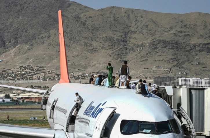 Des Afghans désespérés tentent par tous les moyens de quitter l'aéroport de Kaboul le 16 août 2021