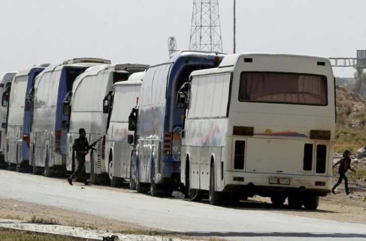 Convoi évacuant des rebelles et des civils de la Ghouta Orientale le 26 mars 2018 à l'entrée d'Harasta en périphérie de Damas (Syrie)
