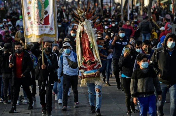 Un pèlerin porte une statue de la vierge de Guadalupe, le 12 décembre 2021 à Mexico
