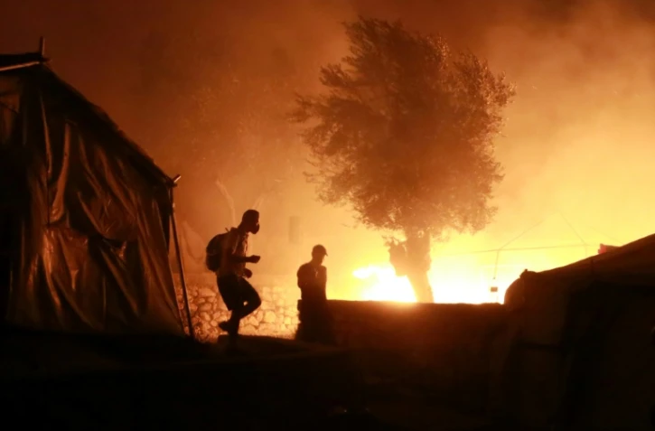 Des migrants dans le camp en feu de Moria, sur l'île grecque de Lesbos, le 9 septembre 2020