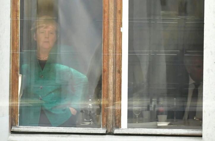 La chancelière allemande Angela Merkel regarde par la fenêtre lors d'une rencontre avec le leader de la CSU bavaroise, Horst Seehofer, à Berlin, le 18 octobre 2017