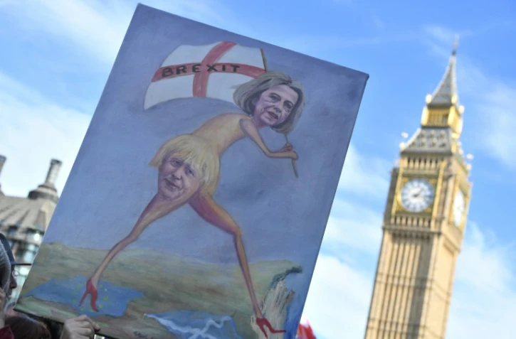 Des manifestants anti Brexit portent un pancarte avec une oeuvre montrant La Première ministre britannique Theresa May et le secrétaire d'État aux Affaires étrangères Boris Johnson, le 25 avril 2017 à Londres