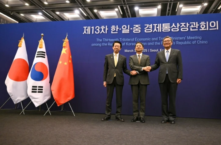 Le ministre sud-coréen de l'Industrie Ahn Duk-geun (centre), le ministre japonais de l'Economie, du Commerce et de l'Industrie Yoji Muto (gauche) et le ministre chinois du Commerce Wang Wentao (droite) à Séoul le 30 mars 2025