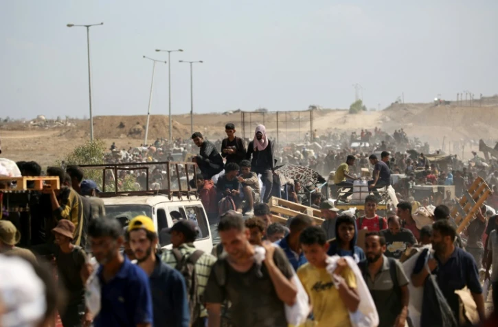 Des Palestiniens revenant d'un site de distribution d'aide de la Fondation humanitaire à Gaza (GHF) soutenue par Israël et les Etats-Unis, dans le centre de la Bande de Gaza, le 3 août 2025