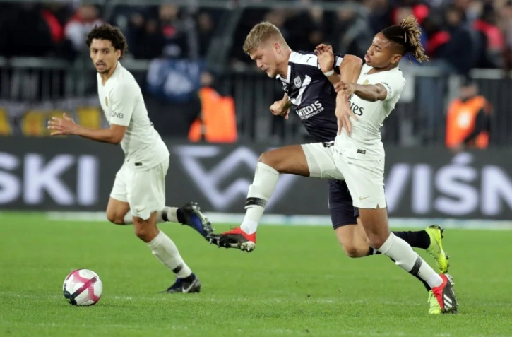 L'attaquant danois des Girondins Andreas Cornelius (c) à la lutte avec le Parisien Christopher Nkunku, le 2 décembre 2018 à Bordeaux 
