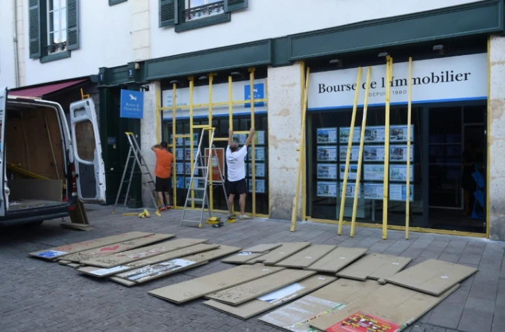 Travaux en cours le 23 août 2019 pour protéger les vitrines d'une agence immobilière à Bayonne