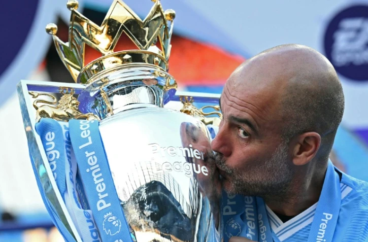 Pep Guardiola embrasse le trophée de la Premier League, le 19 mai 2024 à l'Etihad Stadium