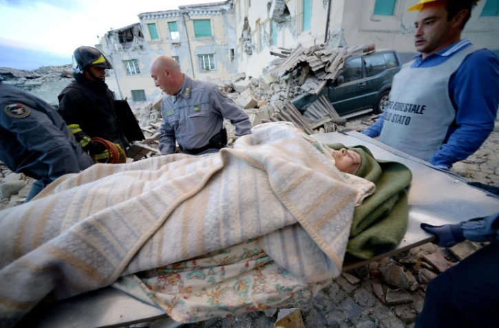 Des sauveteurs transportent un homme à Amatrice, dans le centre de l'Italie, après un fort séisme, le 24 août 2016