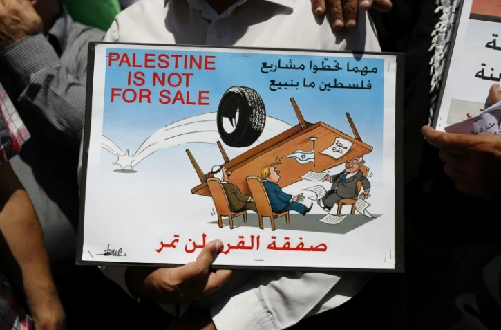 "La Palestine n'est pas à vendre", indique une affiche brandie par un manifestant à Ramallah, en Cisjordanie, le 24 juin 2019