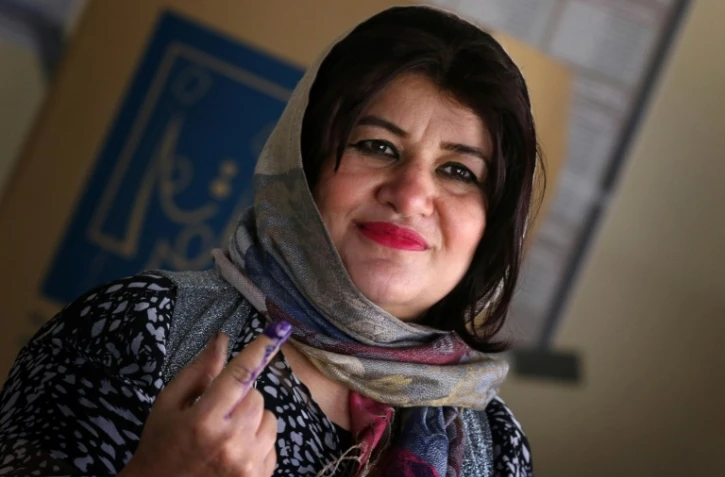 Une femme montre son doigt avec de l'encre dans un bureau de vote à Erbil, capitale du Kurdistan irakien (nord), le 12 mai 2018 lors des élections législatives