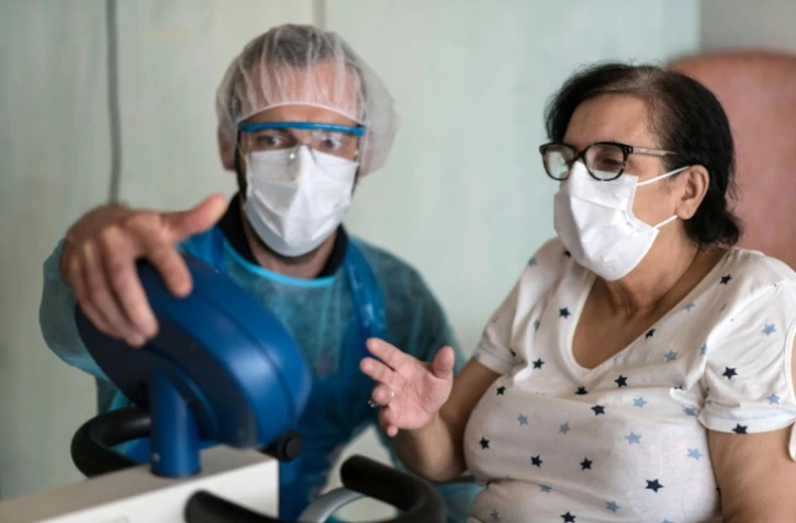 Malika Fisli, atteinte par le coronavirus en mars, lors d'une séance de rééducation avec un médecin de l'unité de médecine physique et réadaptation de l'hôpital Emile Muller, le 29 avril 220 à Mulhouse