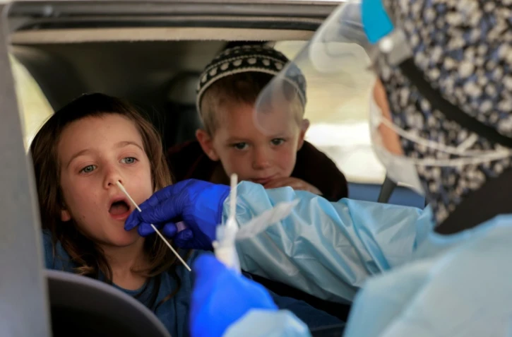 Un médecin pratique un test Covid sur un enfant dans un centre de dépistage de Jérusalem, le 29 juillet 2021