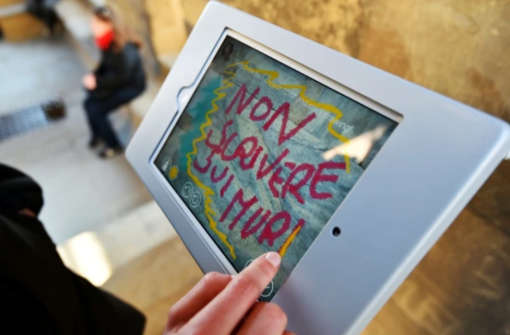 Lors de la visite du Campanile de Giotto à Florence, les touristes sont invités à dessiner leurs grafittis sur des tablettes, le 17 mars 2016