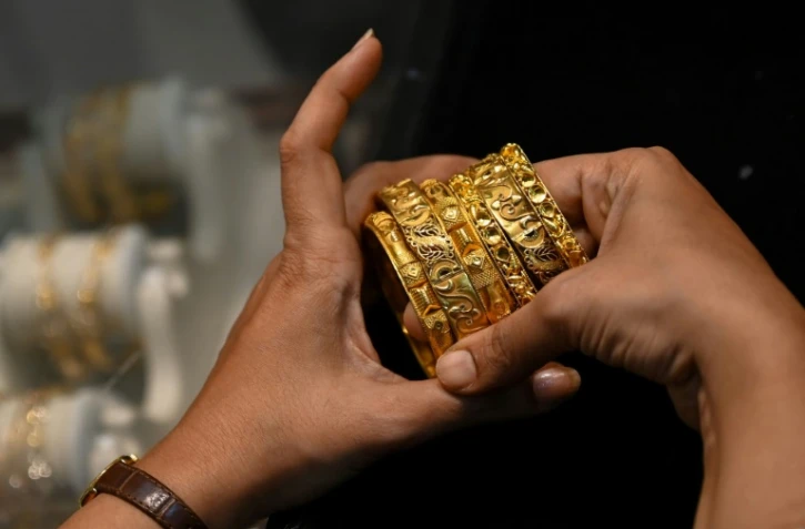 Une cliente admirent des bracelets en or dans une bijouterie de Bombay,le 11 août 2021 en Inde