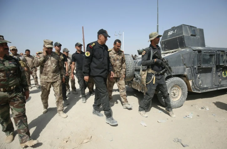 Le général irakien en charge des opérations à Fallouja Wahab al-Saadi (au centre) marche entouré de ses troupes dans la banlieue sud de Fallouja le 1er juin 2016