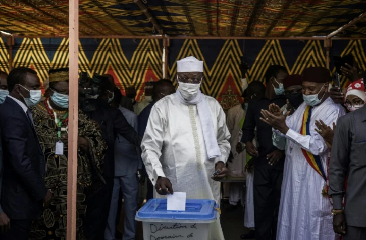 Le président tchadien (C) glisse son bulletin dans l'urne dans un bureau de vote à N'Djamena, le 11 avril 2021