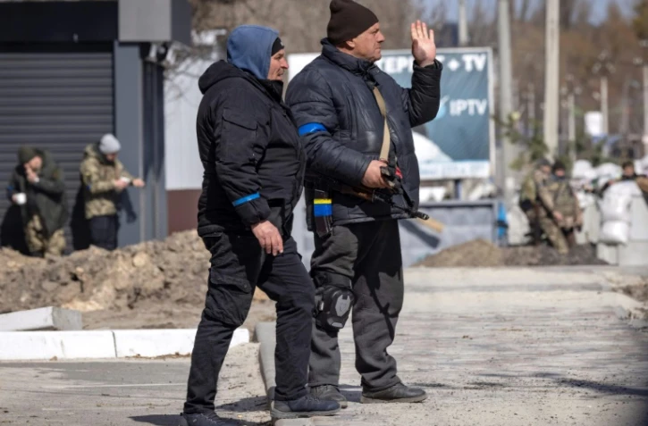 Des volontaires montent la garde à un poste de contrôle à Stoyanka, près de Kiev, le 27 mars 2022