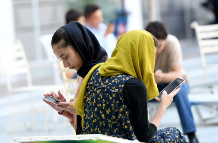Des Afghanes consultent leurs smartphones à Shengjin, le 11 septembre 2021 en Albanie