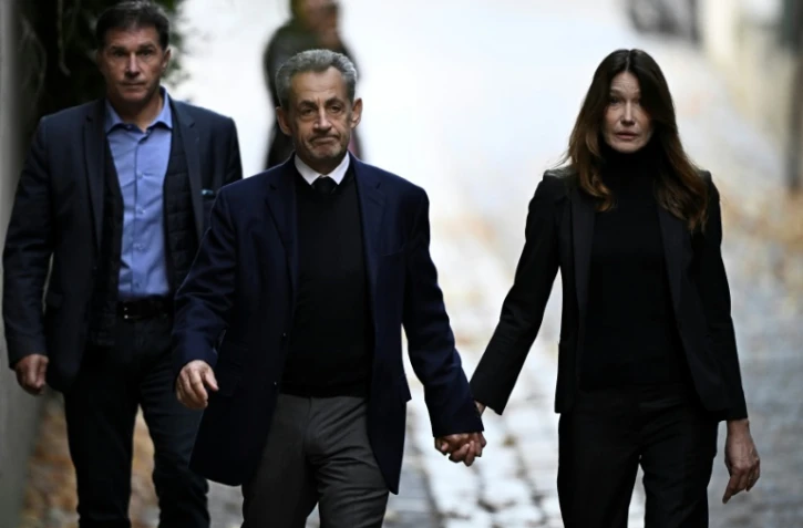 Nicolas Sarkozy (C) et son épouse Carla Bruni-Sarkozy, le jour de son incarcération à la prison de la Santé, le 21 octobre 2025 à Paris