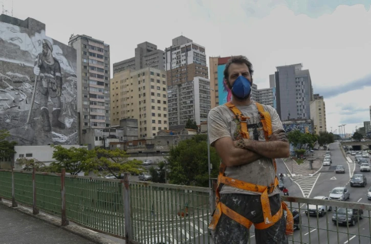 L'artiste brésilien Mundano devant sa fresque de 780m² à Sao Paulo le 13 octobre 2021