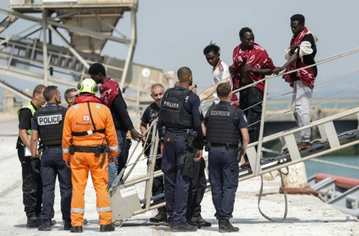 Des migrants débarquent du navire l'Argonaute ; ils ont été secourus en mer après que leur embarcation a pris feu lors d'une tentative de traversée de la Manche au port de commerce de Boulogne-sur-Mer, le 4 août 2026