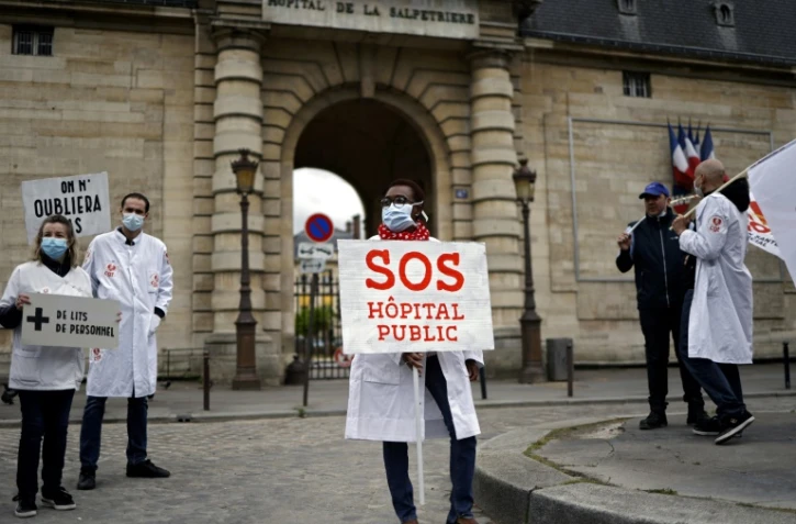 Des personnels soignants et membres du syndicat CGT manifestent devant l'hôpital public de La Pitié-Salpêtrière, le 30 avril 2020 à la veille du 1er mai