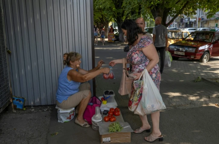 Une femme achète des tomates dans la ville ukrainienne de Marganets ( sud), le 12 août 2022 