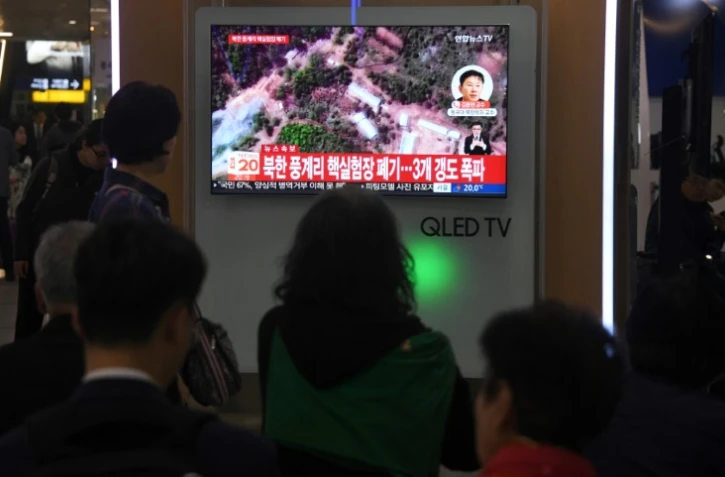 Des Sud-Coréens regardent sur un écran de télévision les informations concernant le démantèlement du site nucléaire nord-coréen de Punggye-ri, le 24 mai 2018 dans une gare de Séoul