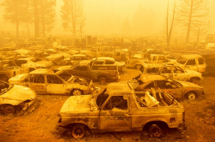 Des dizaines de véhicules brûlés sont plongés dans les épaisses fumées dégagées par le Dixie Fire à Greenville (Californie), le 6 août 2021
