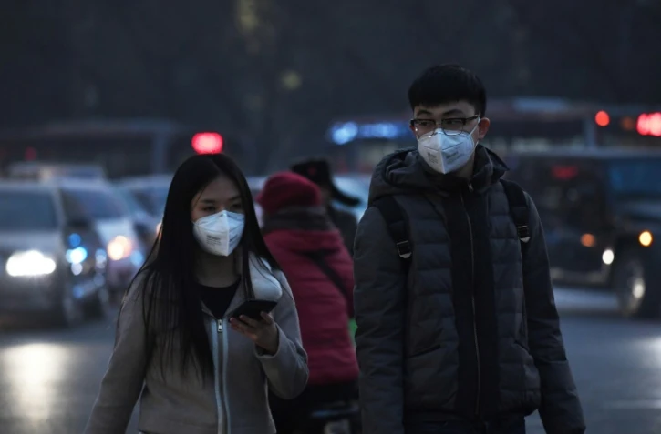Des piétons équipés de masques pour se protéger de la pollution le 19 décembre 2016 à Pékin