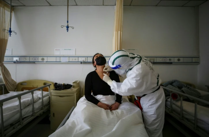 Un malade du COVID-19 reçoit un traitement à l'hôpital de la Croix Rouge à Wuhan, le 11 mars 2020