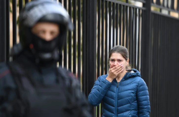 Une femme en proie à l'émotion à l'entrée du campus de l'université de Perm (Russie), le 21 septembre 2021, au lendemain d'une tuerie qui a coûté la vie à six personnes