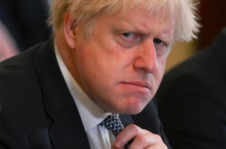 Le Premier ministre britannique, Boris Johnson, ajustant son noeud de cravate le 24 mai 2022 lors d'une réunion à Downing Street