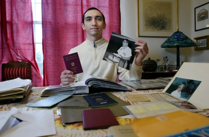 L'Américain Noah Rohrlich montre son nouveau passeport autrichien et une photo de son grand-père Fritz Rohrlich, le 16 mars 2021 à Falls Church, aux Etats-Unis