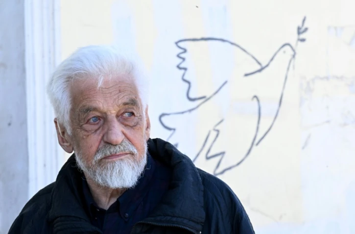 L'artiste Vladimir Ovtchinnikov devant l'un de ses graffitis à Borovsk, à une centaine de kilomètres au sud-ouest de Moscou, le 14 avril 2022