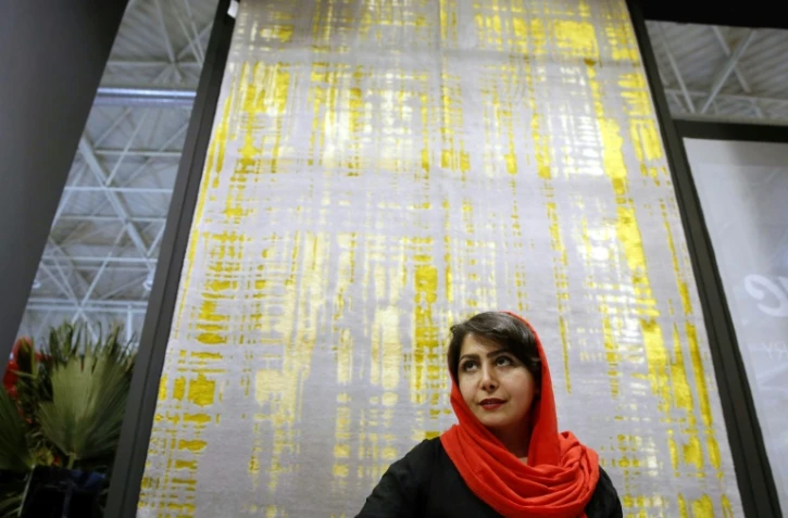 Une visiteuse devant un tapis fabriqué à Ispahan, lors d'une exposition de tapis, le 26 août 2022 à Téhéran