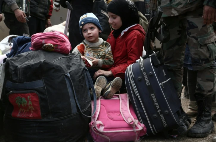 Enfants syriens évacués de la poche sud de la Ghouta orientale, aux portes de Damas, à leur arrivée le 31 mars 2018 dans le village de Qalaat al-Madiq, à 45 km au nord-ouest de la ville centrale de Hama